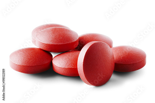 Heap of medical pills in red color on isolated white background. Concept of healthcare and medicine.