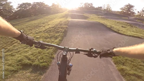 Riding bicycle on city asphalt pump track, first person point of view POV. Man riding on tarmac track, extreme sports from first person perspective. Gimbal stabilized video GOPRO HERO5. photo