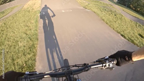 Riding bicycle on city asphalt pump track, first person point of view POV. Man riding on tarmac track, extreme sports from first person perspective. Gimbal stabilized video GOPRO HERO5. photo