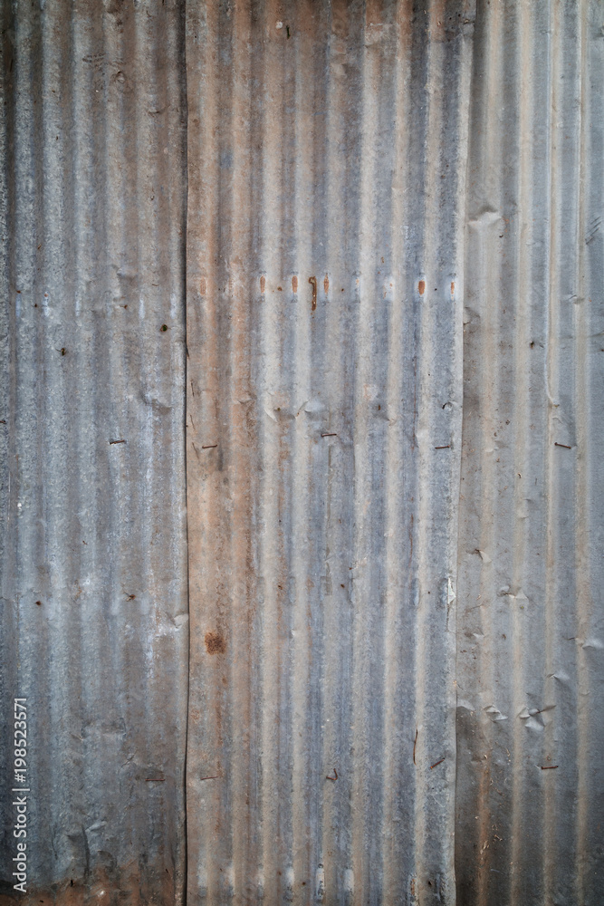 Faded and corrugated iron metal construction site wall texture background with vignette. Faded and corrugated iron metal construction site wall texture background with vignette.