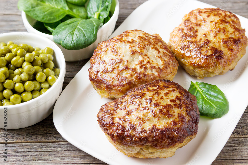 Homemade cutlets with a salad on a plate in a rustic style. Homemade cutlets with a salad on a plate in a rustic style.