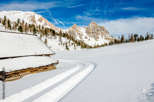 Trails on a white field of snow, that cover the alpine pasture of Fodara on the Fanes dolomites