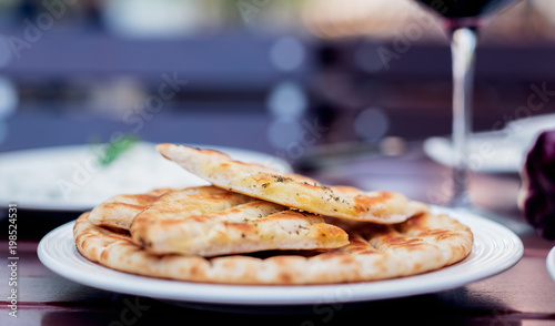 Photos Griechisches Pita Brot mit Gewürzen vom Grill mit Rotwein im Garten serviert