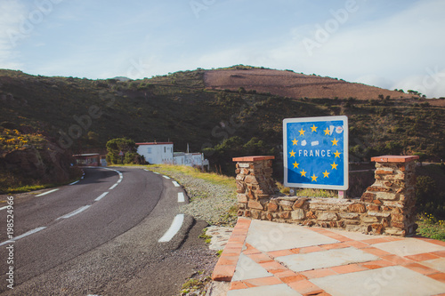 French border road sign with European Union blue flag and yellow stars between France and Spain frontier