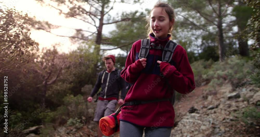 Group of friends with backpacks hiking in a forest Group of friends with backpacks hiking in a forest