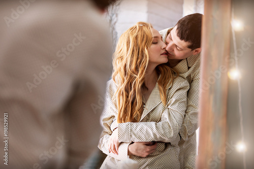 young couple in pajamas early in the morning at home.The reflection in the mirror.Family life.