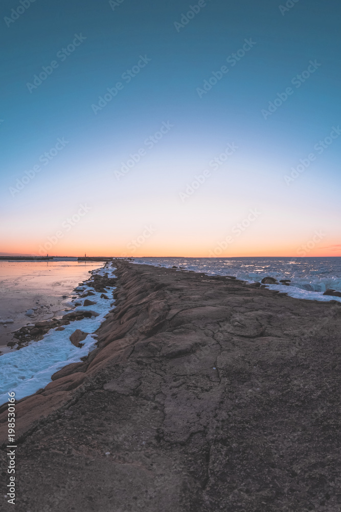 Sunset on the pier by the frozen Baltic sea Sunset on the pier by the frozen Baltic sea