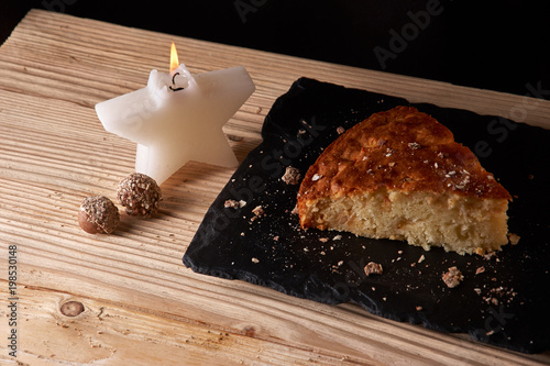 Home baked apple pie on shale board and wooden table near Candle in the form of stars