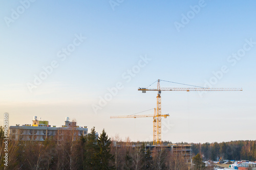 Construction cranes at a construction site at sunset in early spring