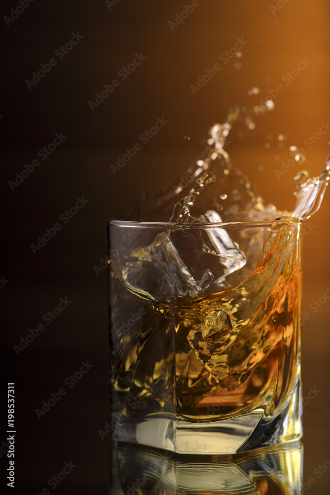A Glass Of whiskey with ice and gold light A Glass Of whiskey with ice and gold light