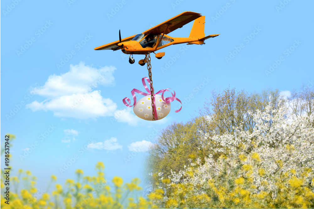 Samolot ultralekki, awionetka transportuje ogromne Wielkanocne jajo. - obrazy, fototapety, plakaty 