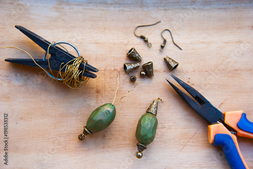 Assembly of ethnic earrings with pliers and wire. Hobby, handycraft. Education, working process.