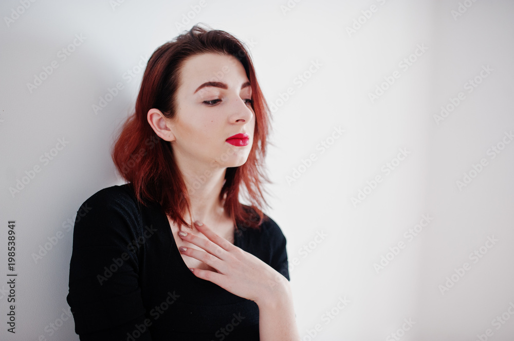 Red haired girl on black dress tunic against white wall at empty room. Red haired girl on black dress tunic against white wall at empty room.