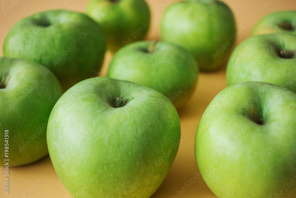 Ripe green apples on a pastel peach background Ripe green apples on a pastel peach background