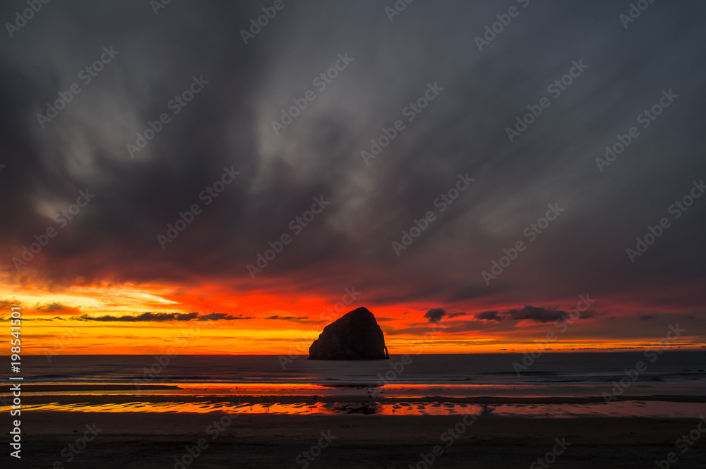Fototapeta premium Sunset behind Rock under dark clouds in Cape Kiwanda