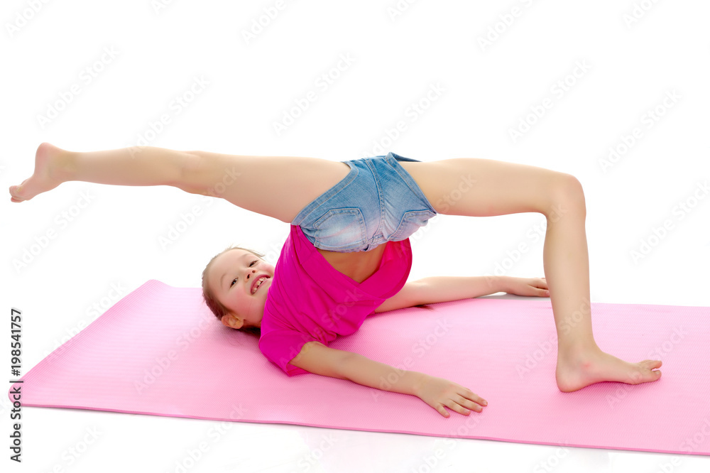 The little gymnast perform an acrobatic element on the floor. The little gymnast perform an acrobatic element on the floor.