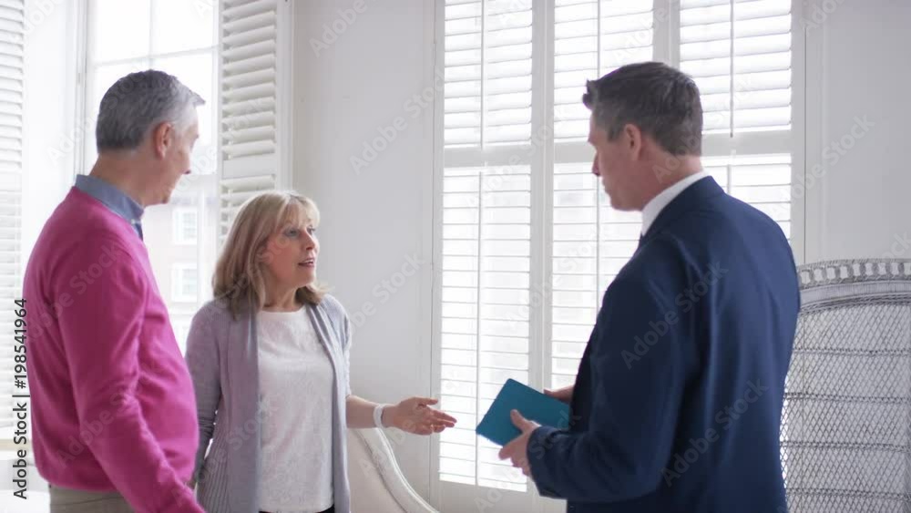 Mature couple agree on a property with real estate agent and shake hands Mature couple agree on a property with real estate agent and shake hands