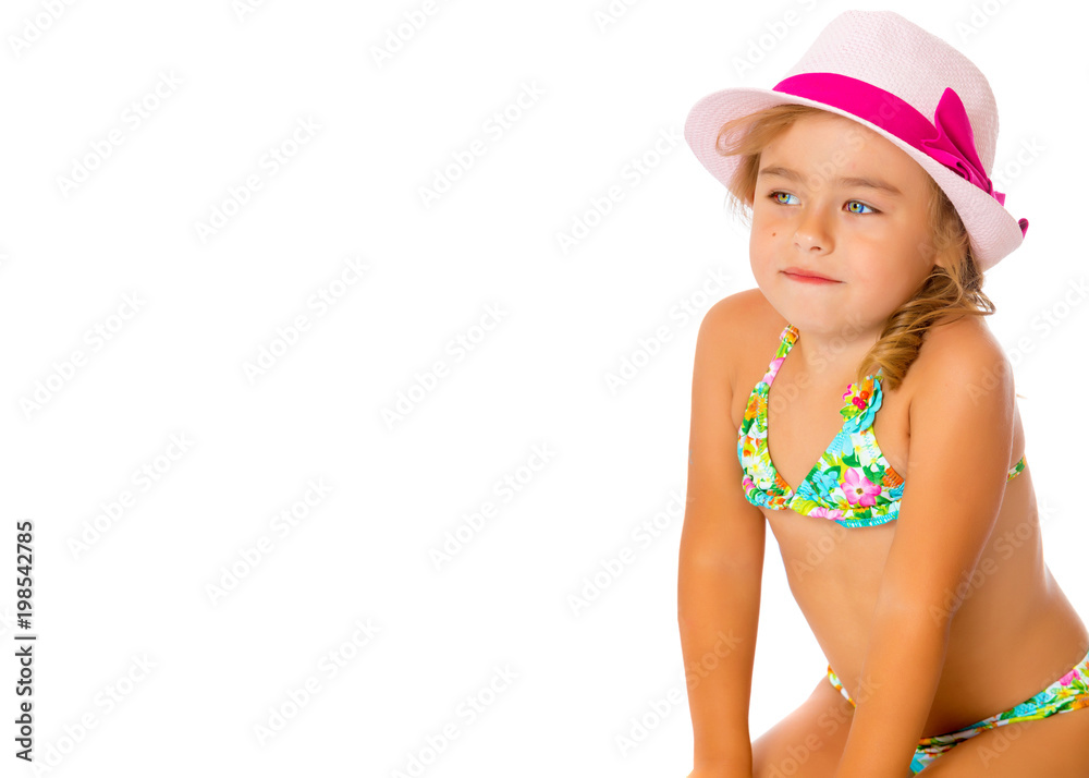 A small tanned girl in a swimsuit and a hat.