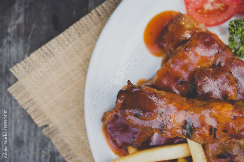Chinese cuisine. Roasted baked pork ribs with sauces on the white plate. Selective focus.