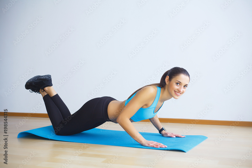 Side view of fit woman doing plank core exercise.