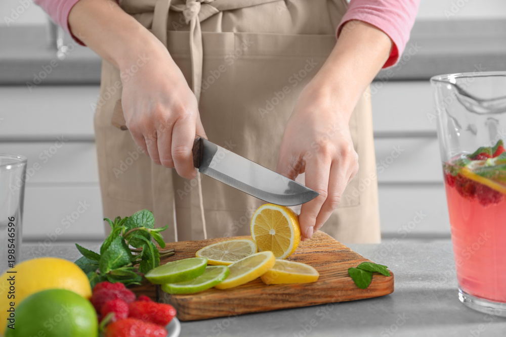 Woman preparing fresh lemonade on table Woman preparing fresh lemonade on table