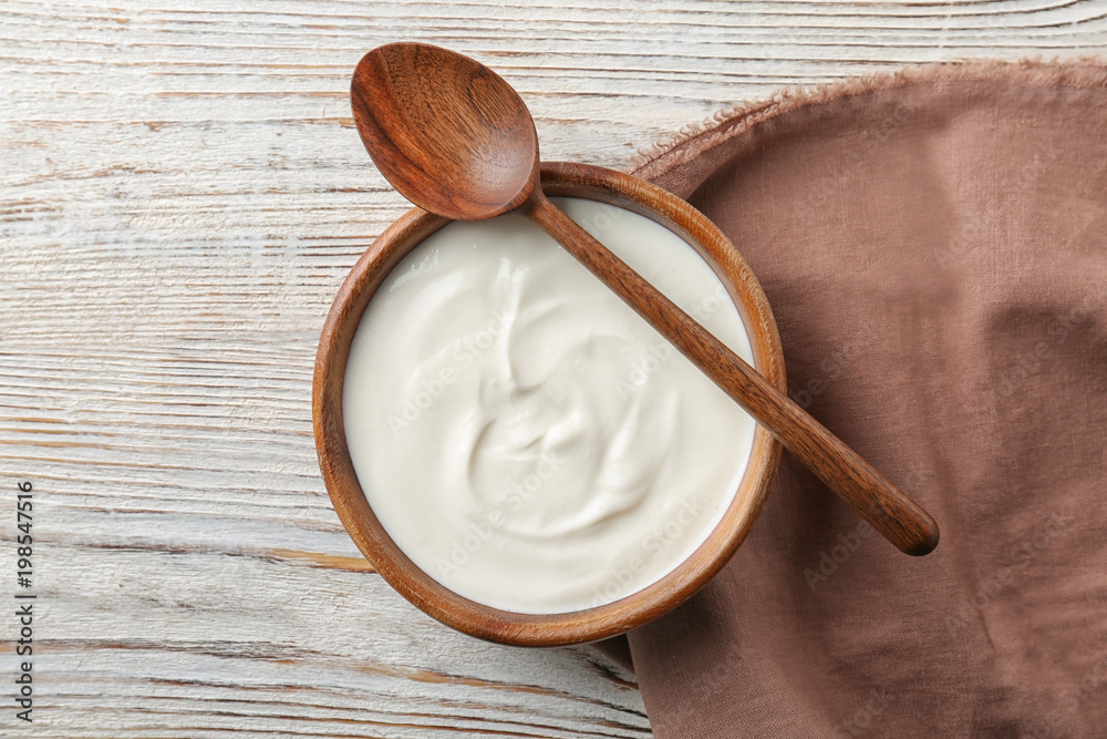 Bowl with tasty yogurt on wooden background Bowl with tasty yogurt on wooden background