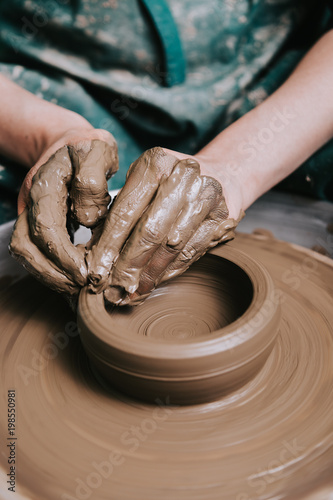 Hands working on pottery wheel