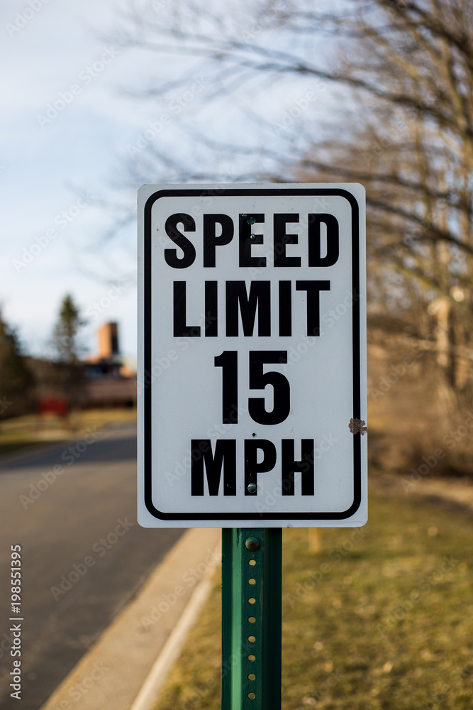 Speed limit sign 15 mph in a peaceful neighborhood in spring