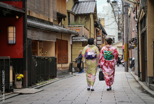Women in traditional dress that call kimono, are walking on the stone pavement in culture street at Gion, Kyoto, Japan. © Uraiwon