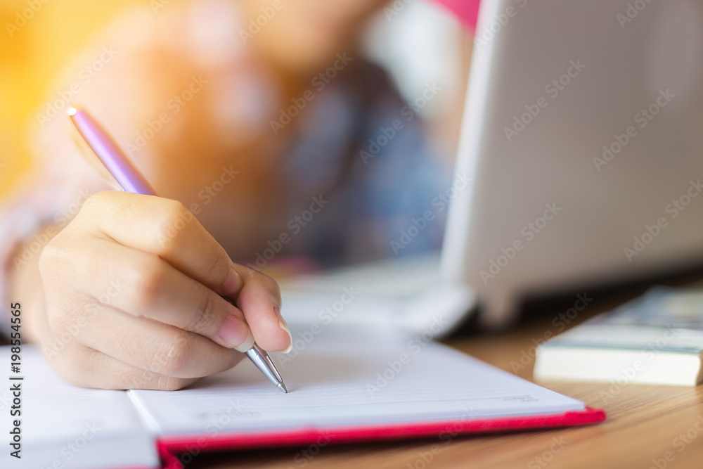 female hand write on book for work at home