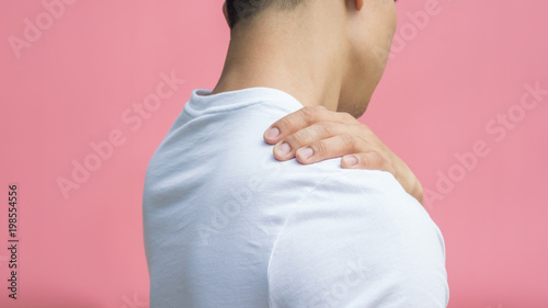 Wallpaper Mural Men feeling pain in his shoulder on a pink background. Torontodigital.ca