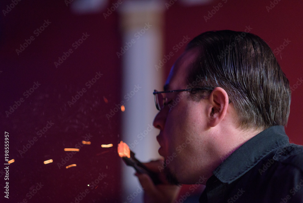 Fototapeta premium Male model smoking hookah in a night club