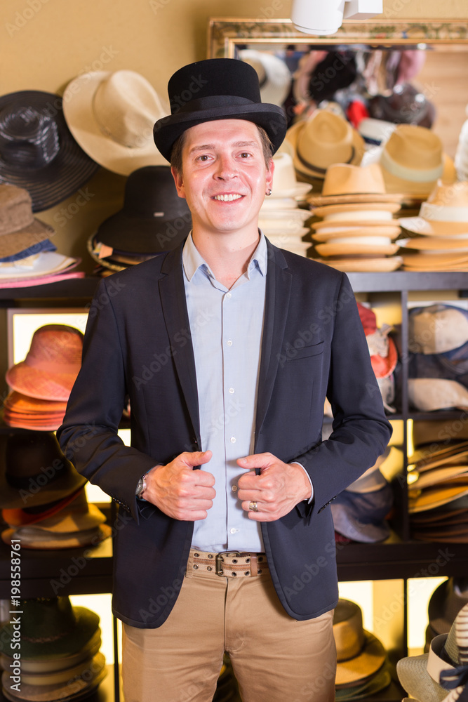 adult male shopping in botique and try on cylinder hat