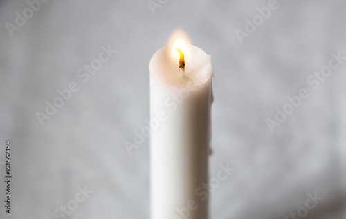 The hand lights a white candle