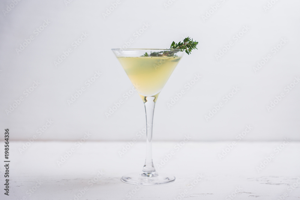 Tasty bitter cocktail with thyme in martini glass. Selective focus. Tasty bitter cocktail with thyme in martini glass. Selective focus.