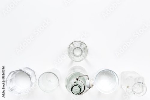Drinking water in bottles and glasses on white background top view copy space