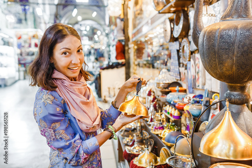 Woman tourist walking among countless shops in Grand Bazaar market in Istanbul. Shopping and travel in Turkey concept