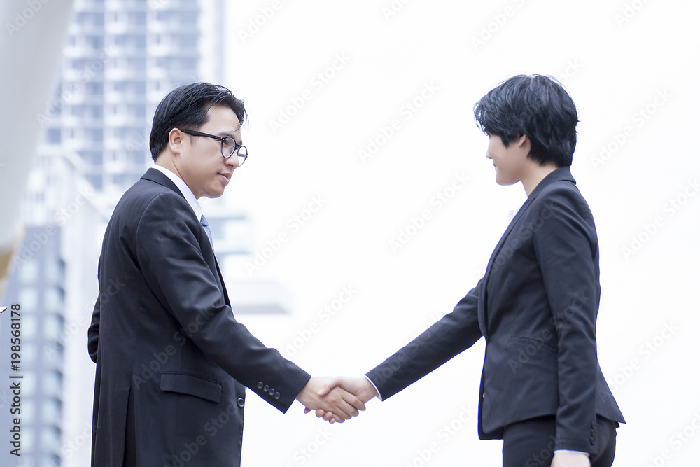 Business men and women shaking hands with a smile on the background Business men and women shaking hands with a smile on the background