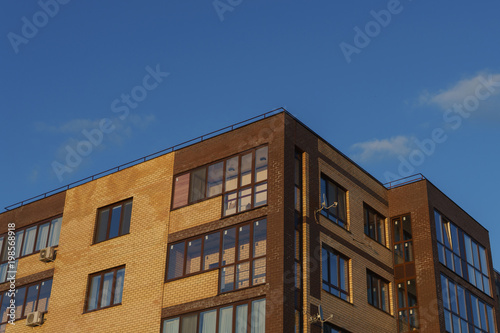 New apartment building with balconies against the blue sky