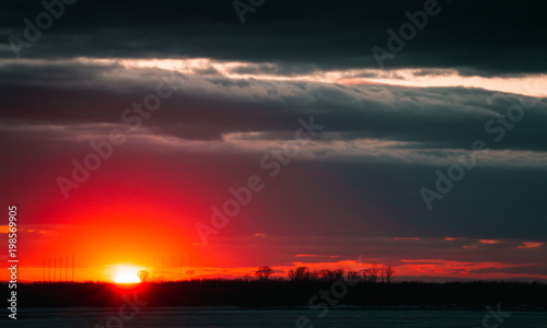 A beautiful sunset on the embankment of the city of Khabarovsk with beautiful textured images and a bloody sun