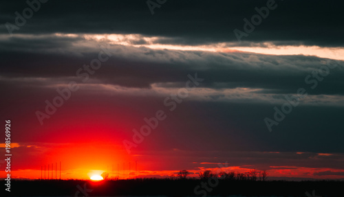 A beautiful sunset on the embankment of the city of Khabarovsk with beautiful textured images and a bloody sun