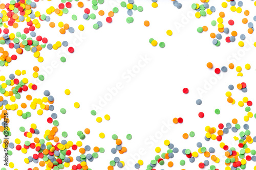 Colorful sweet confetti topping on white background with copy space at the center