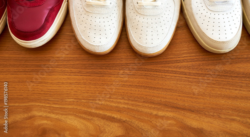Top View Of Three Pair Of Red And White Sneaker Shoes On A Wooden Surface Top View