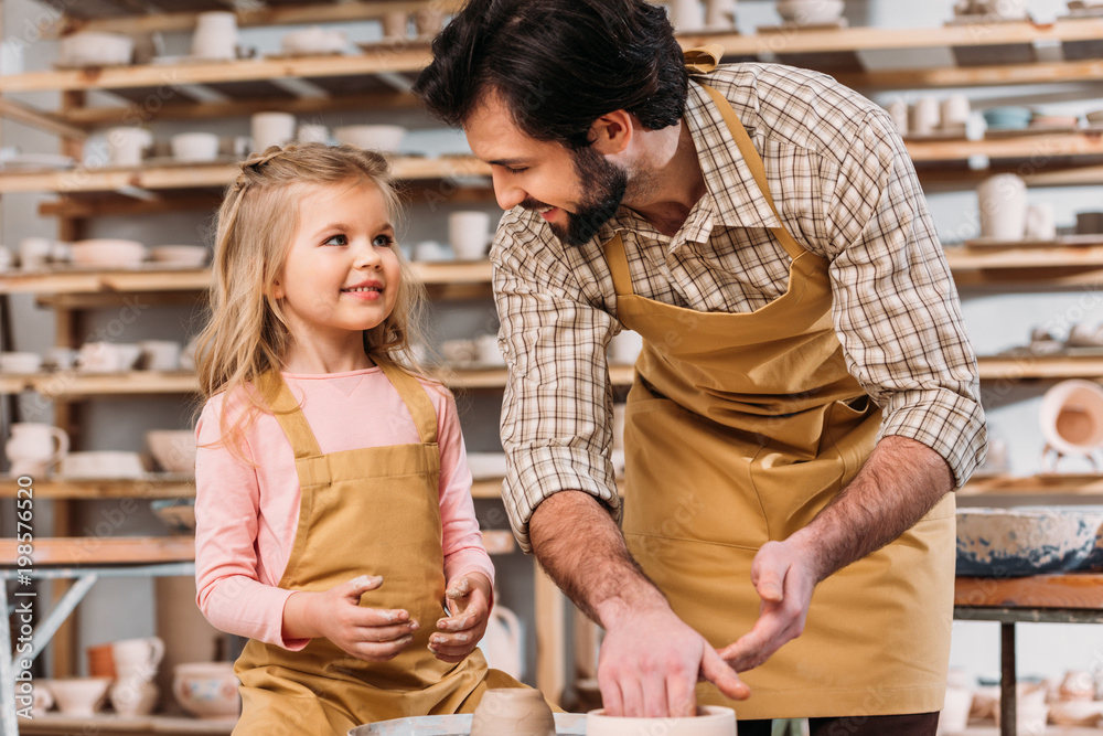 adorable child with teacher using pottery wheel in workshop adorable child with teacher using pottery wheel in workshop