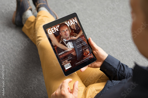 Man reading magazine on tablet