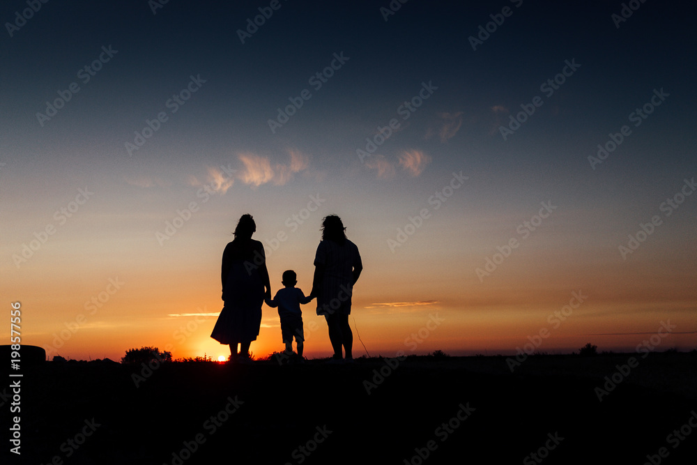 Three members of the family watching sunset