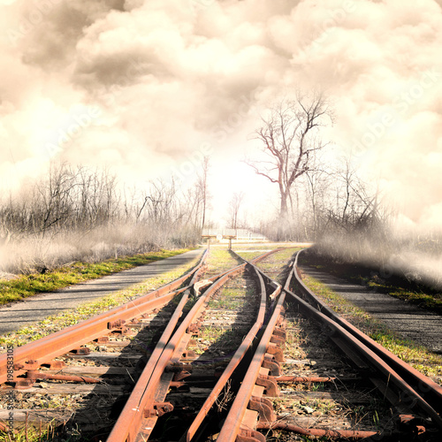 rotaie ferroviarie in campagna con paesaggio nebbioso