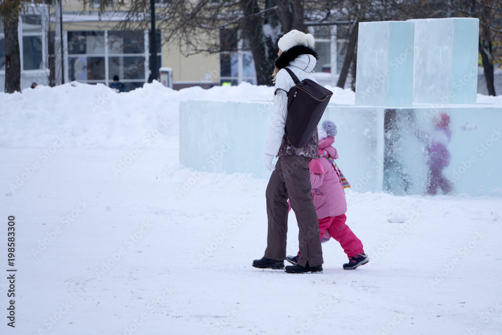 Classic tourist vacation in happy young mother and daughter in winter in the square .