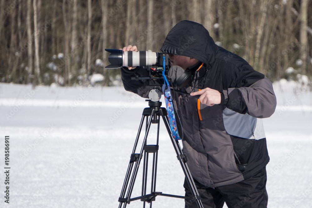 videographer working in the snow in summer mountain .