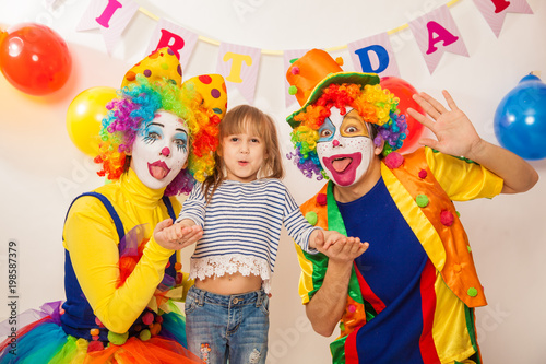 clown girl and clown boy at the birthday of a child. Party for children. Clowns and little girl show different emotions